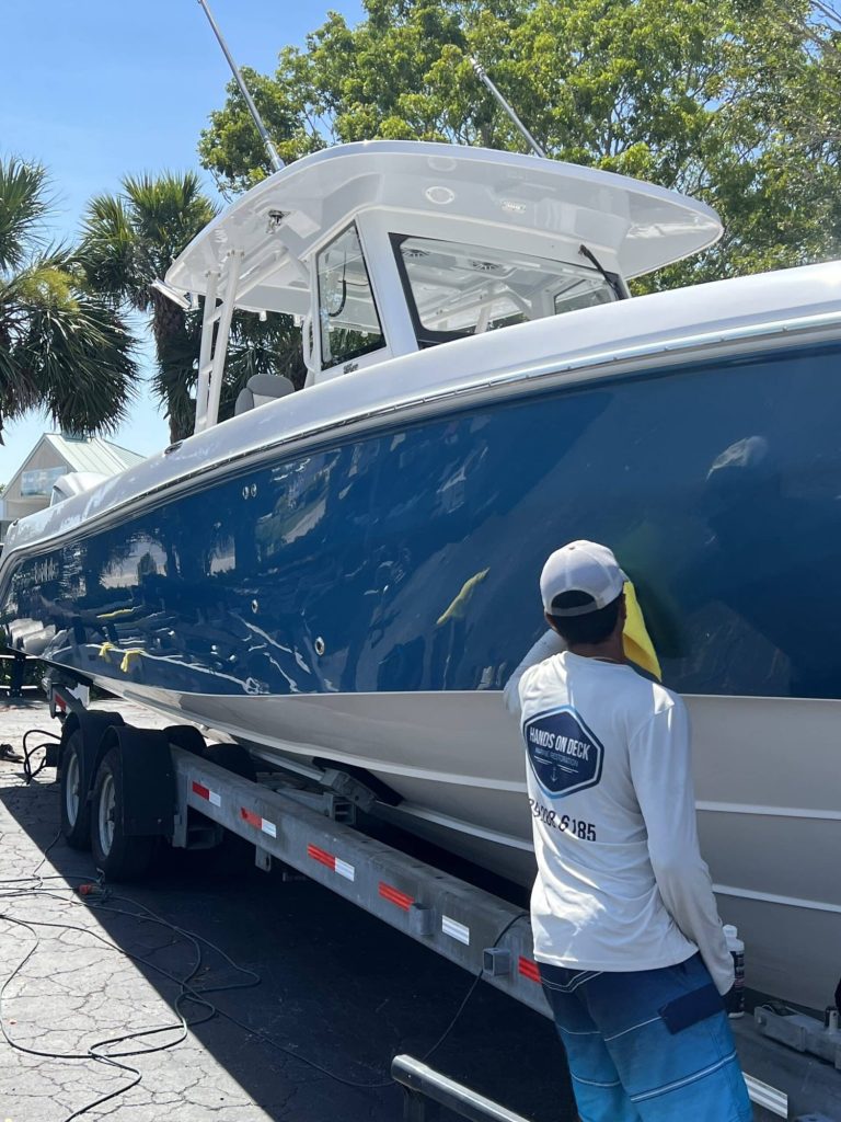 Crew member with a blue-hull boat on a trailer