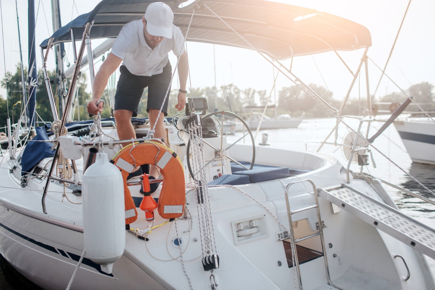 Sailor checking deck gear on a sailboat at the marina